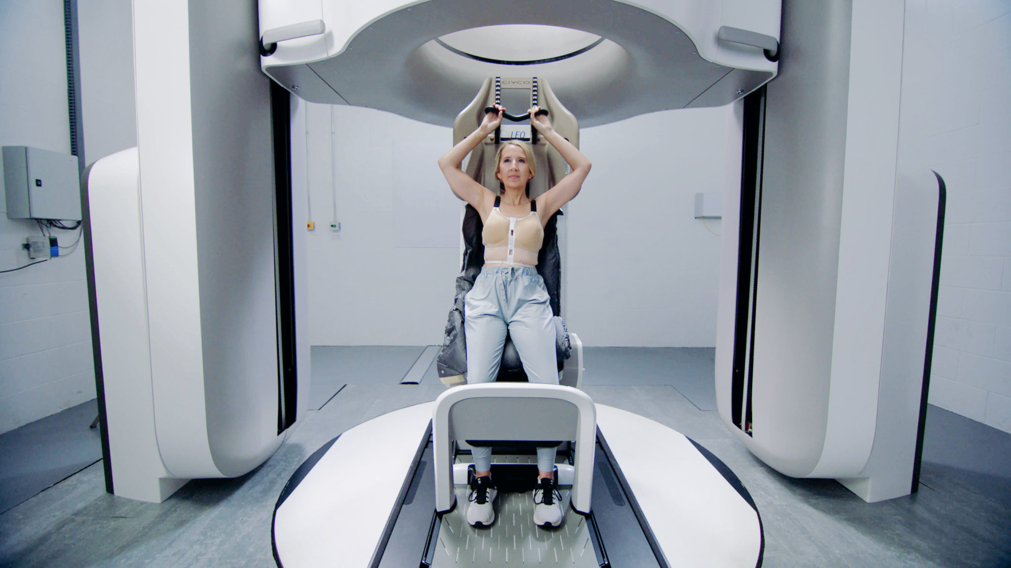 A woman positioned in the Leo Cancer Care upright radiotherapy solution demonstrating a breast treatment setup